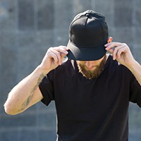 a man wearing a black shirt and a black baseball cap